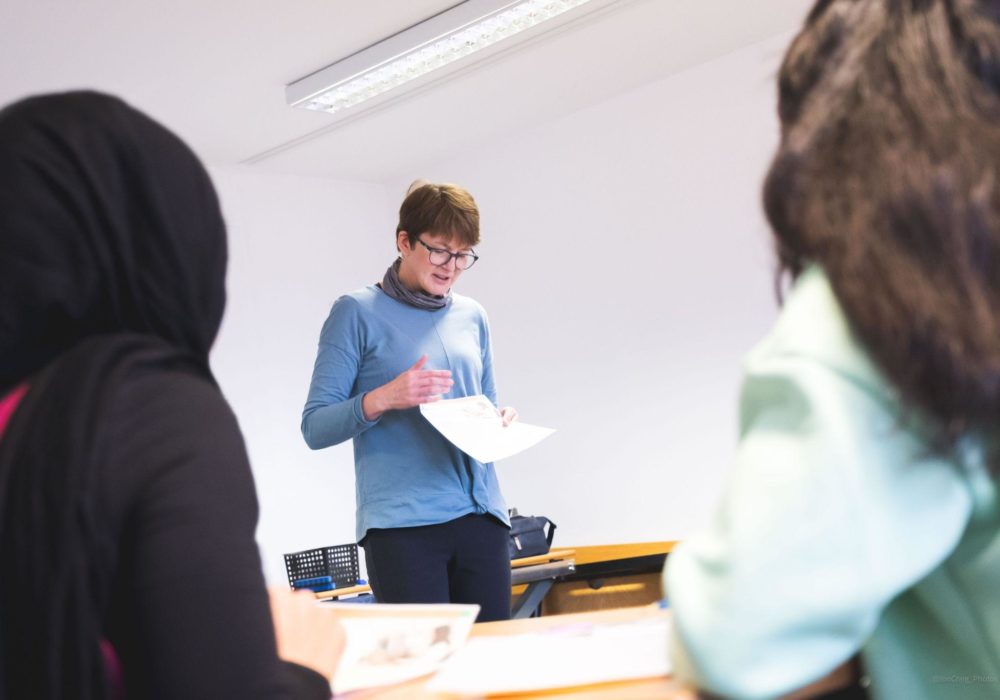 Students in foreground facing the teacher